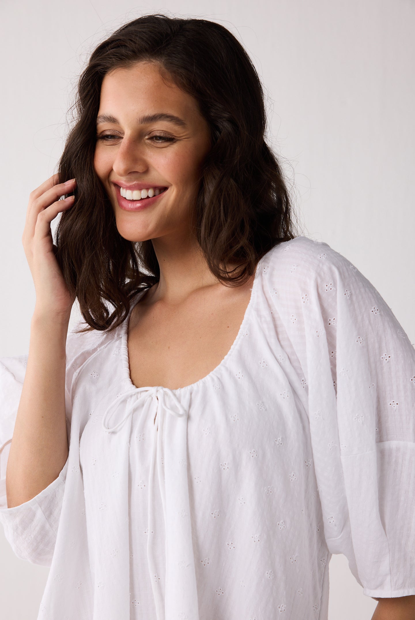 Woman wearing a white blouse against a plain background
