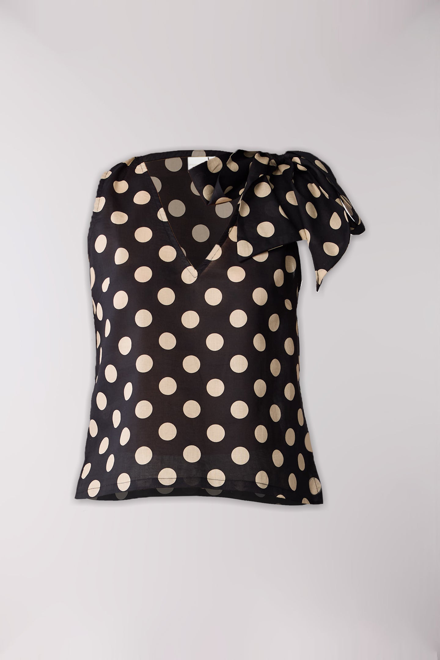 Black top with polka dots on a light gray background