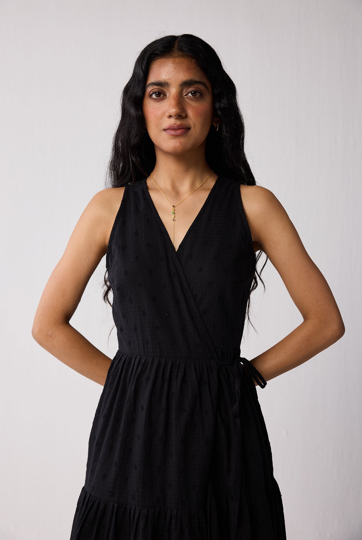 Woman wearing a black dress against a plain background
