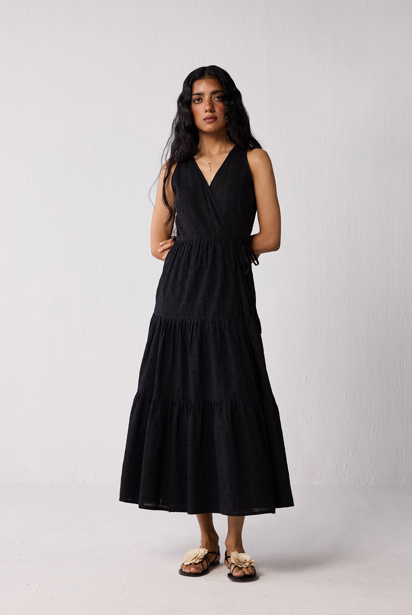 Woman wearing a black sleeveless dress against a white background