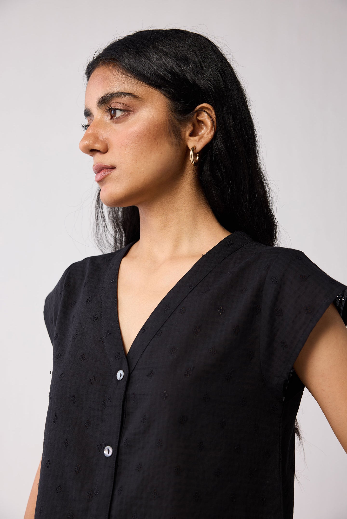 Woman wearing a black top against a plain background