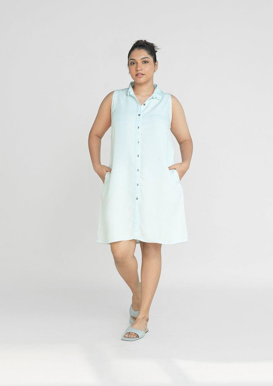 Reistor Dreaming of Blue Skies Dress, sleeveless button-front shirt dress in soft blue with side pockets, a relaxed sustainable women's summer dress.