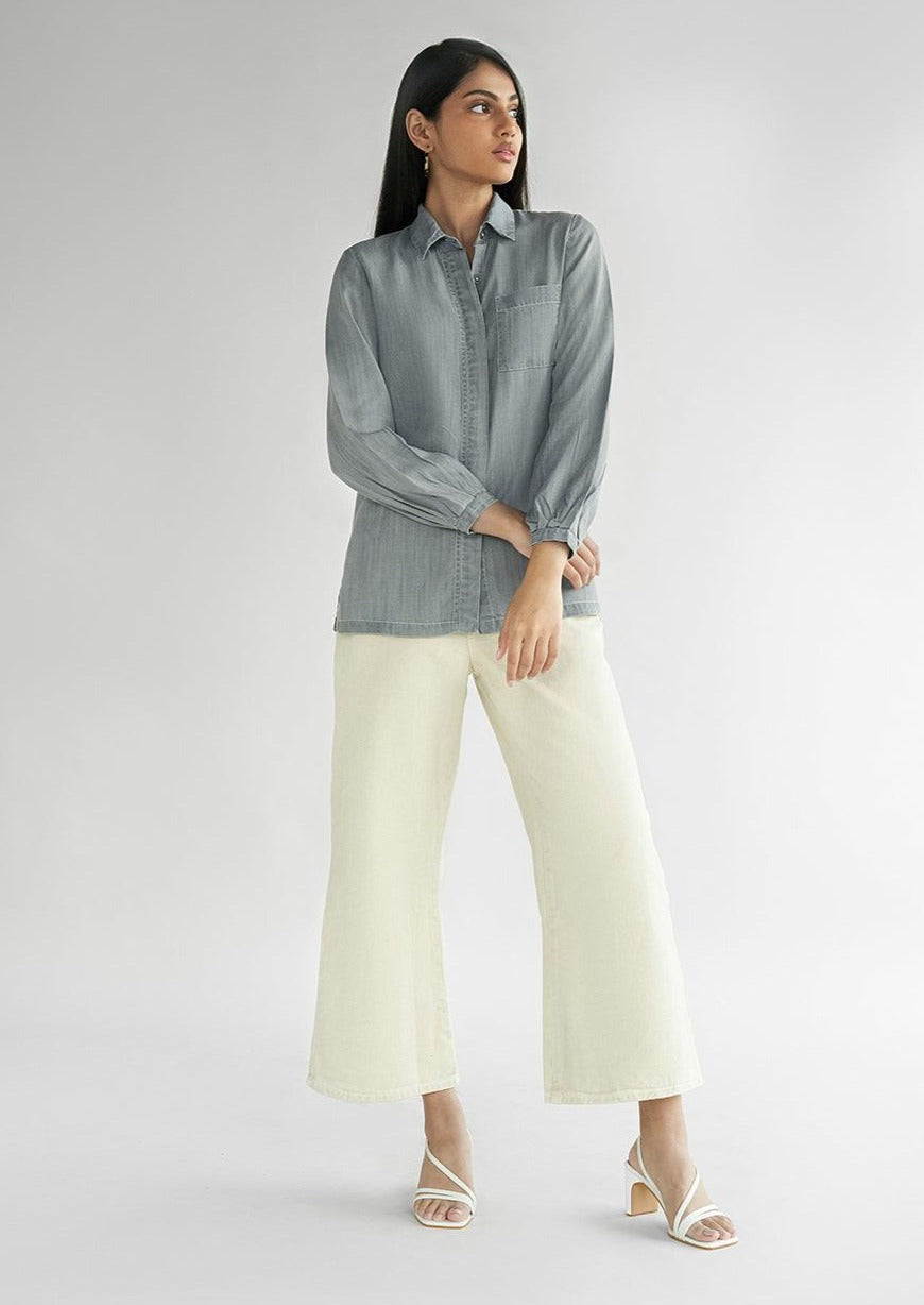 Model wearing the Reistor Shades of Everyday Top in Stone Grey, showcasing a classic collar, chest pocket, full sleeves and timeless casual elegance.