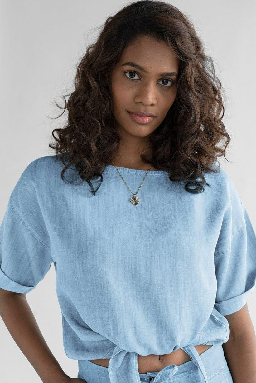 Reistor Twist and Sway Top in Blue, women's blue crop top featuring a tie-fitted waist, loose cap sleeves, and breathable sustainable fabric for everyday style.