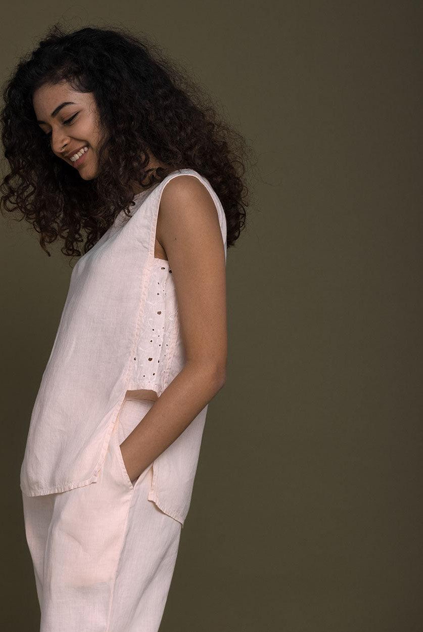pastel pink sleeveless top with embroidered detailing on the sides. Reistor