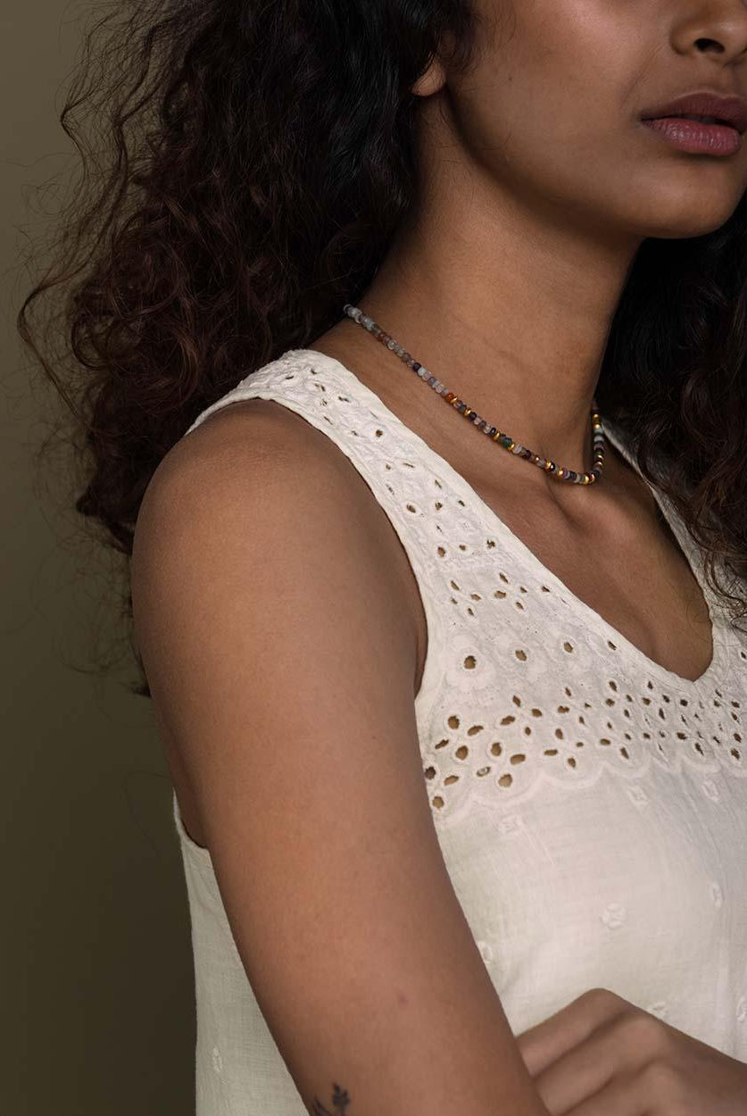 off white T back top with a v neck and embroidered details front and behind