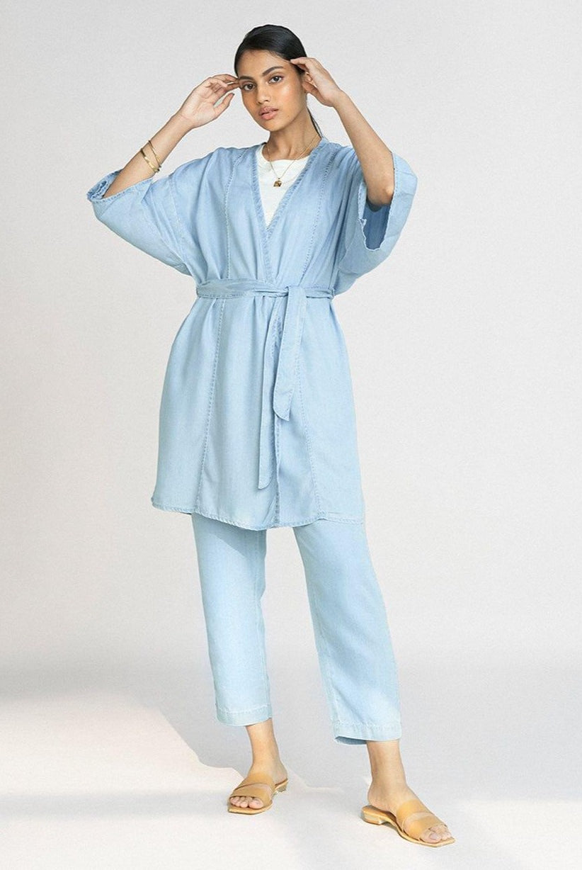 Full-length view of the Reistor Wrapped in Happiness Overlay in Ocean Blue, featuring a tie-waist design, relaxed kimono sleeves and lightweight fabric.