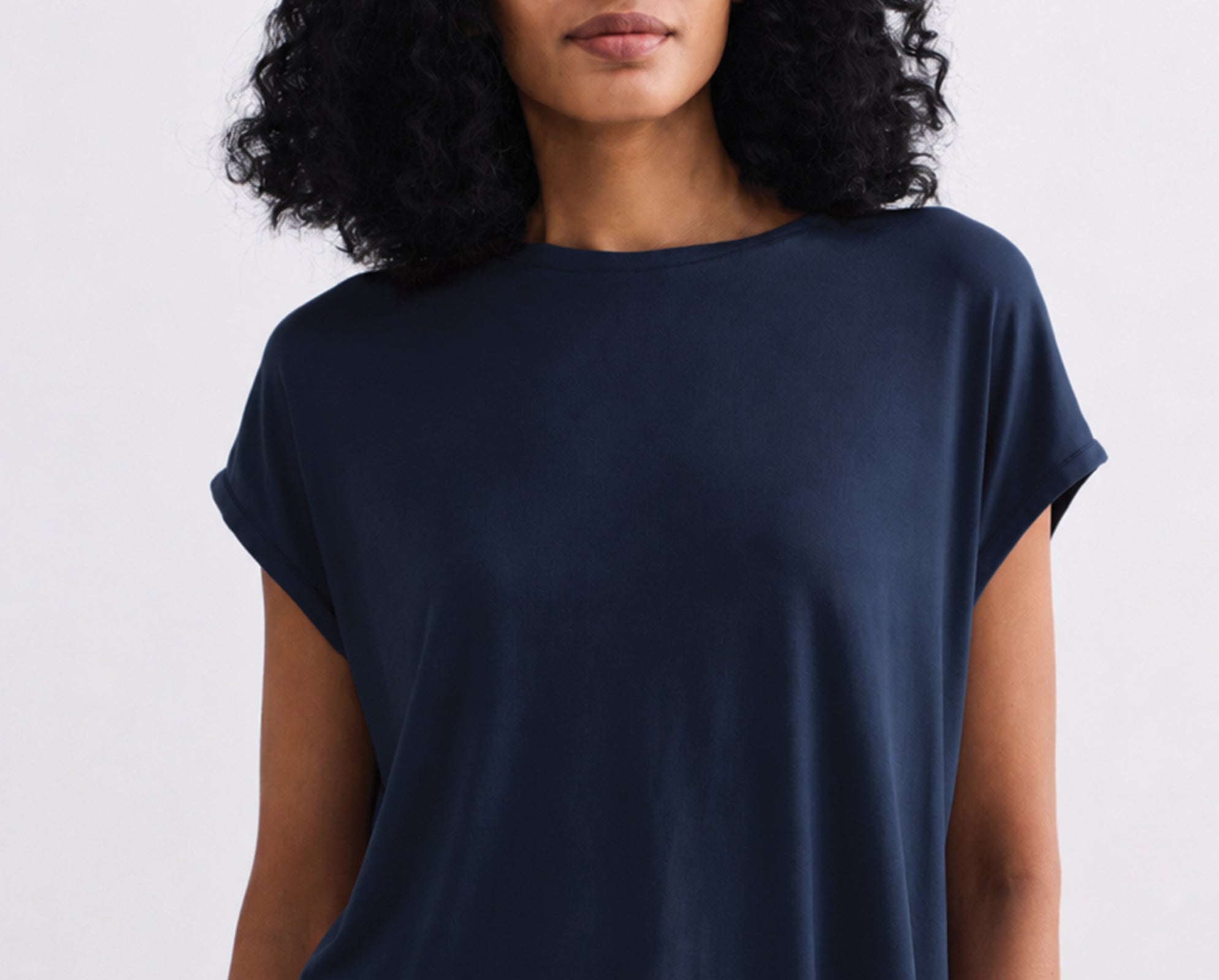 Woman wearing a navy blue t-shirt against a light gray background