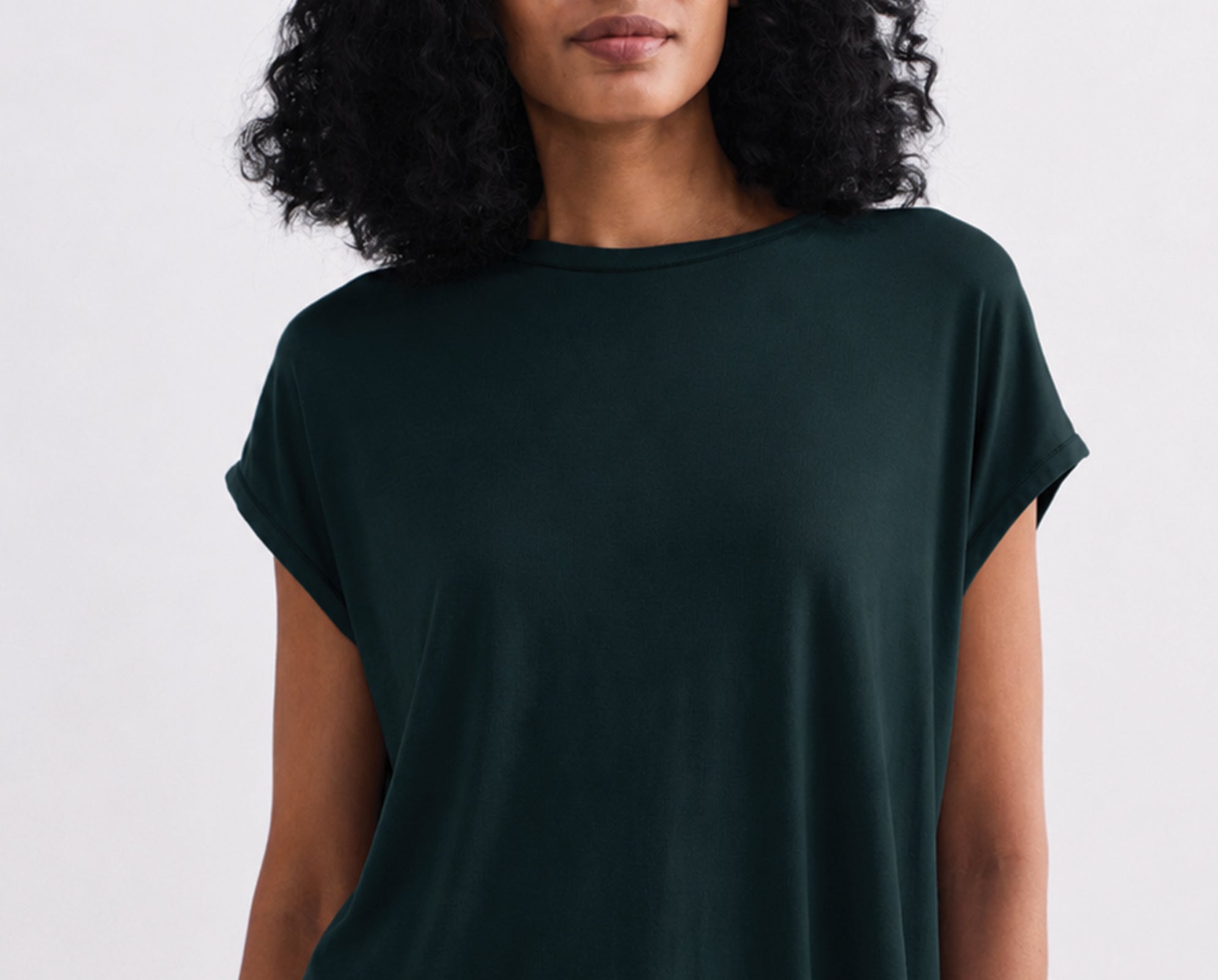Person wearing a teal t-shirt against a plain background