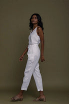 Reistor sleeveless white belted jumpsuit with tapered legs, side profile in sustainable women's everyday fashion.