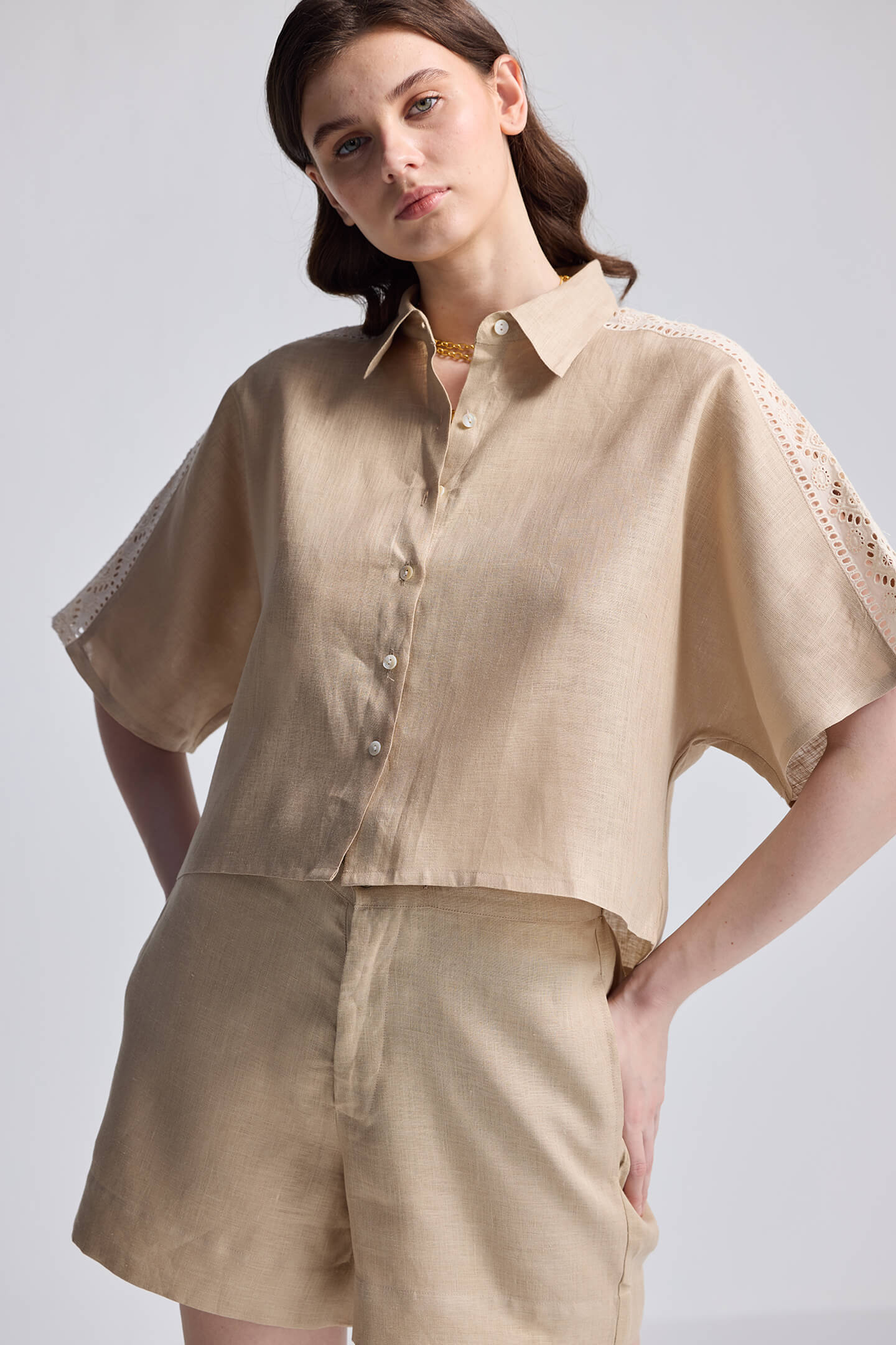 Front view of Boxy Shirt with Lace by reistor in beige, featuring a relaxed boxy fit, button-down front, collared neckline, and delicate lace detailing on the short sleeves, paired with matching shorts against a neutral background.