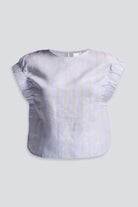 Close-up of a model wearing the reistor Boxy Top with Sleeve Detailing in a blue and tan vertical stripe pattern, paired with white shorts.