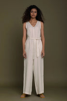 Reistor sleeveless V-neck beige wide-leg jumpsuit with tie waist, sustainable women's fashion for effortless style.