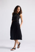 Model wearing Reistor Breezy Summer Set in Black, featuring a sleeveless crop top and flowy midi skirt styled with flat sandals for a minimalist summer look.