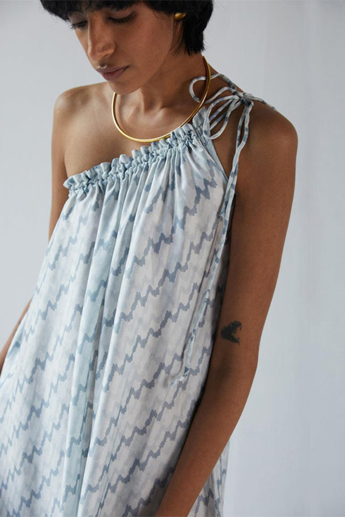 Woman wearing the Reistor Dancing in the Moonlight Dress, a light blue patterned sustainable dress with a relaxed fit, perfect for effortless summer style.