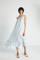 Woman wearing the Reistor Dancing in the Moonlight Dress, a light blue one-shoulder sustainable dress with a flattering silhouette, perfect for summer outings and vacations.