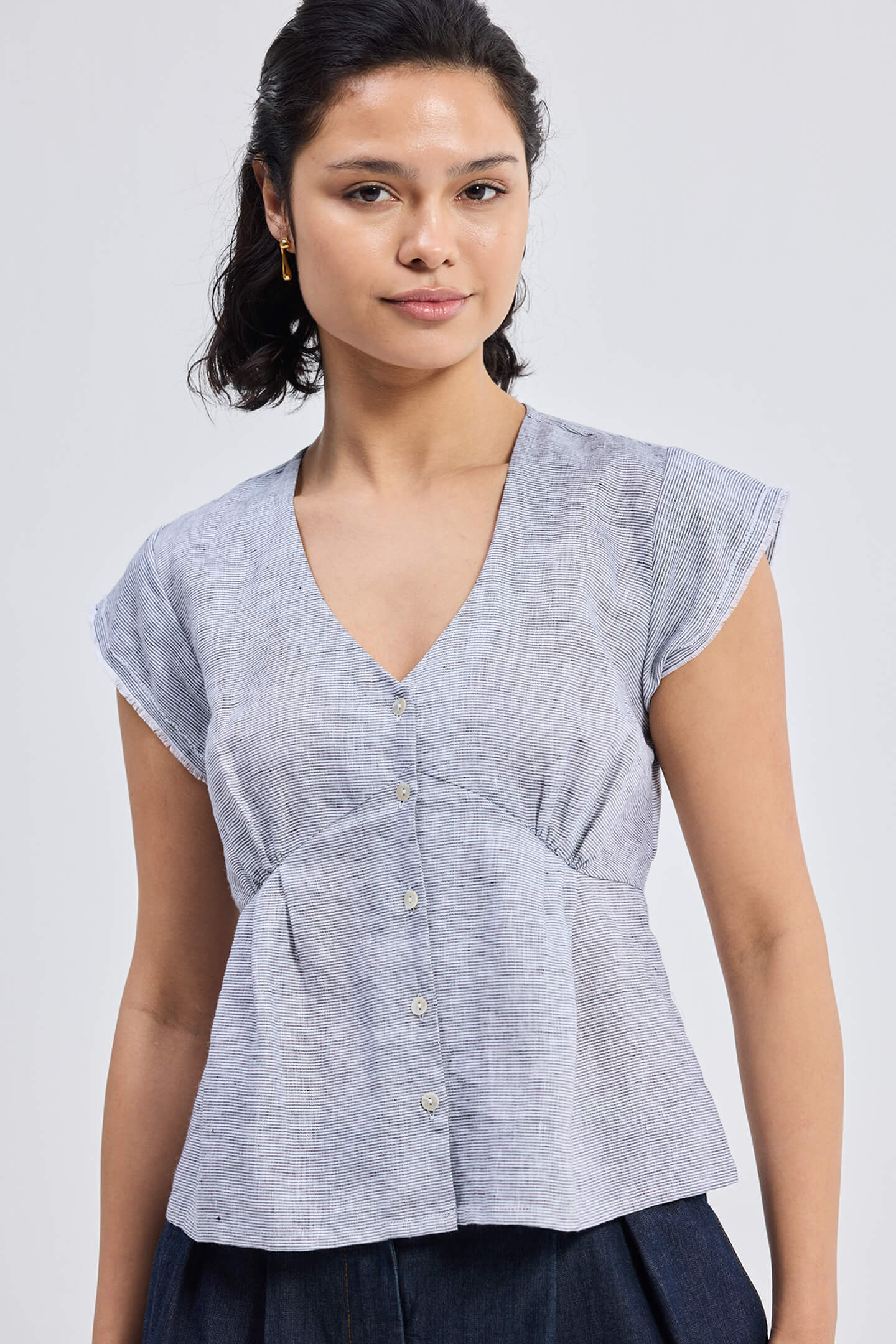 Deep V-neck short top in Linen Stripes by reistor featuring cap sleeves, front button detail, and breathable lightweight linen fabric in a relaxed fit design.