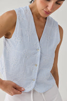 Embroidered Sleeveless Vest Top in Blue Stripe featuring delicate tonal floral embroidery, a subtle striped texture, V-neckline, and button-front closure, shown in a close-up view highlighting the intricate detailing and relaxed fit.
