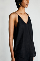 Woman wearing the Reistor Endless Sunday Top in Black, a sleeveless sustainable women's top with a relaxed fit, perfect for everyday wear and effortless styling.
