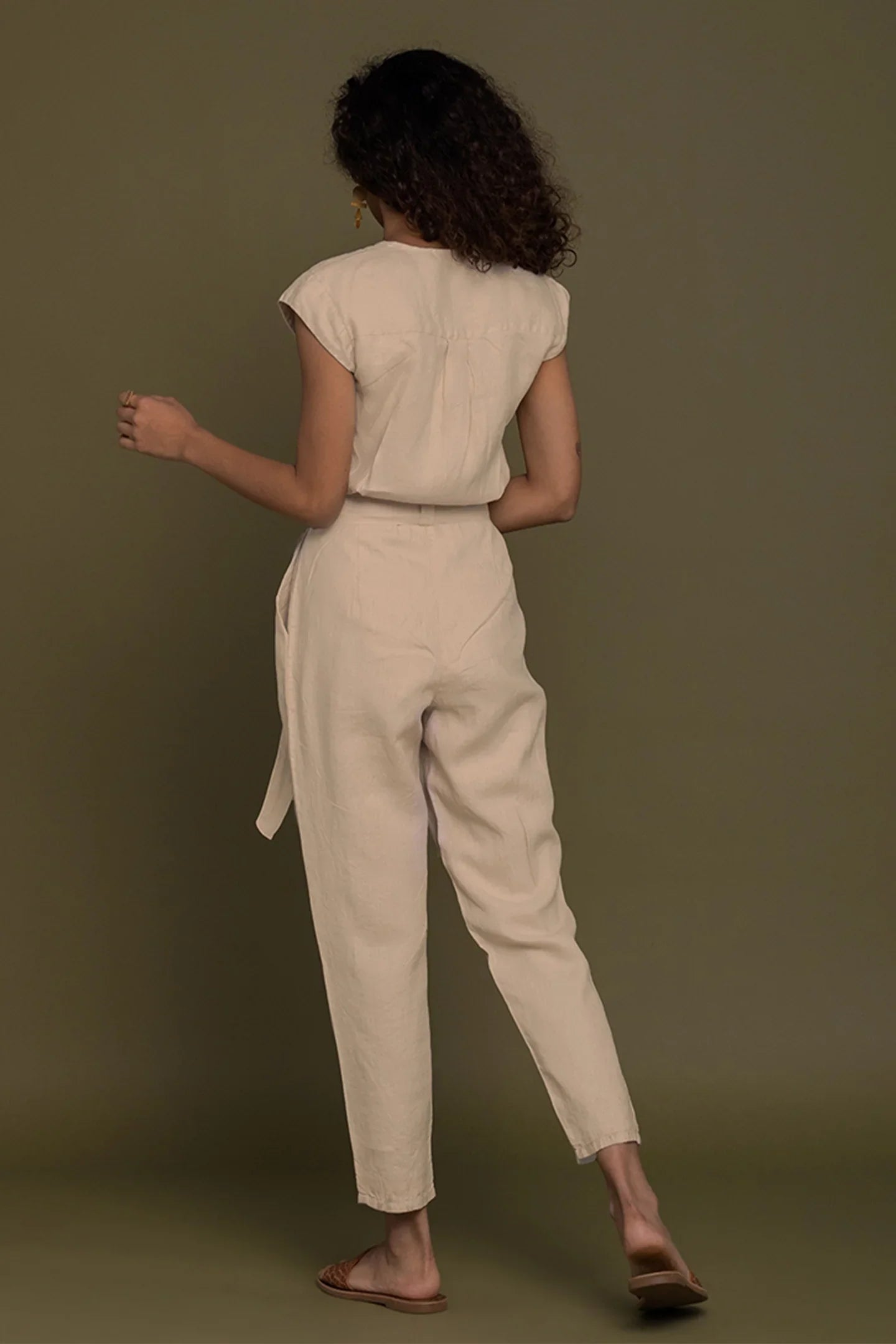 Back view of Reistor Evening Chai Jumpsuit in Neutral Beige with tie waist, timeless sustainable women's fashion.
