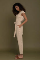 Reistor Evening Chai Jumpsuit in Neutral Beige for women, side profile with tie waist, pockets and relaxed fit