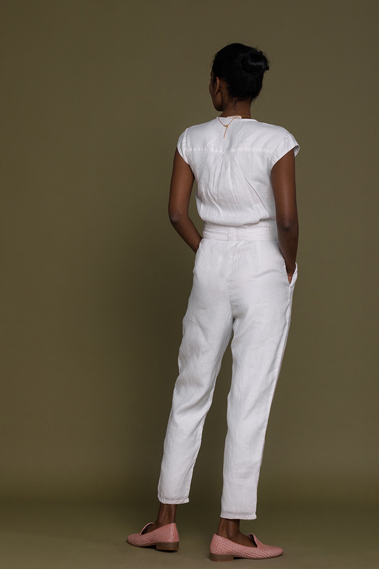 Reistor Evening Chai Jumpsuit in White showcasing the back view with a relaxed fit, tie waist, and breathable fabric