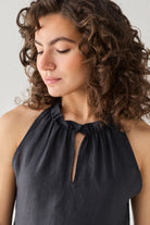 Reistor Halter Neck Top in Black featuring an elegant keyhole opening and softly ruched neckline, captured in a close-up portrait that highlights its refined craftsmanship and timeless appeal.