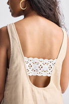 Back view of model wearing Reistor Hemp Short Dress with Back Embroidered Lace Detail, featuring a deep scoop back and intricate white lace embroidery.
