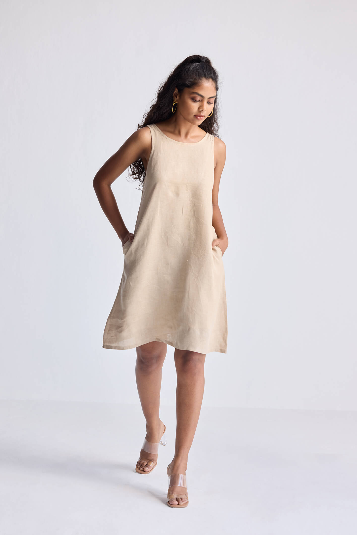Full-length view of model wearing Reistor Hemp Short Dress with Back Embroidered Lace Detail in a neutral beige shade, sleeveless silhouette with a relaxed fit.