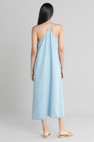 Back view of the Reistor In the Mood for Love Denim Midi Dress, featuring delicate cross-back straps, a flowing silhouette and lightweight denim fabric.