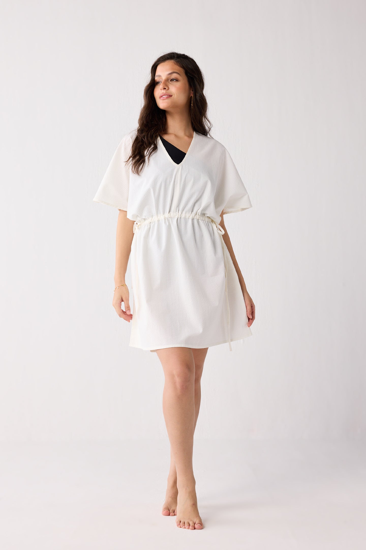 Woman wearing a white dress against a plain background