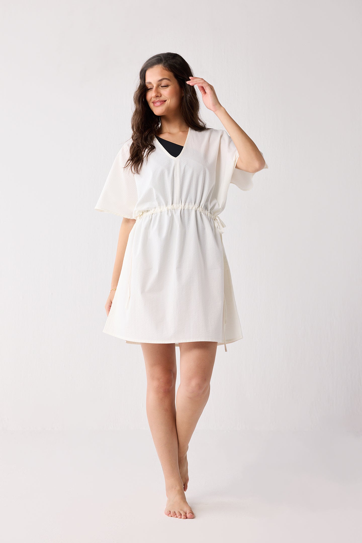 Woman wearing a white dress on a plain background