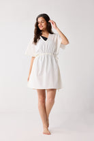 Woman wearing a white dress on a plain background