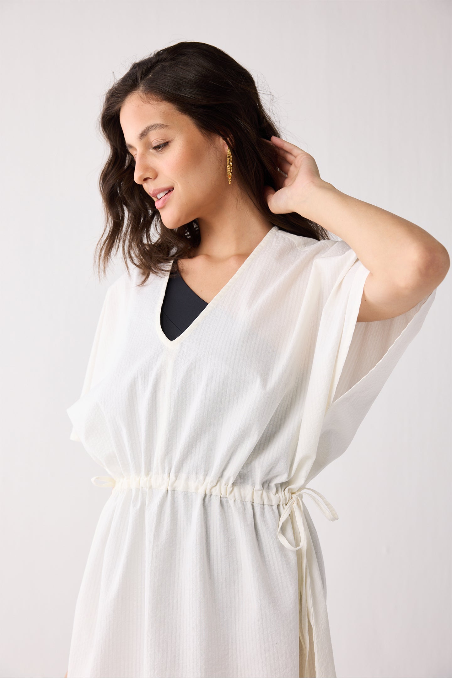 Woman wearing a white dress against a plain background