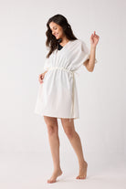 Woman wearing a white dress against a plain background