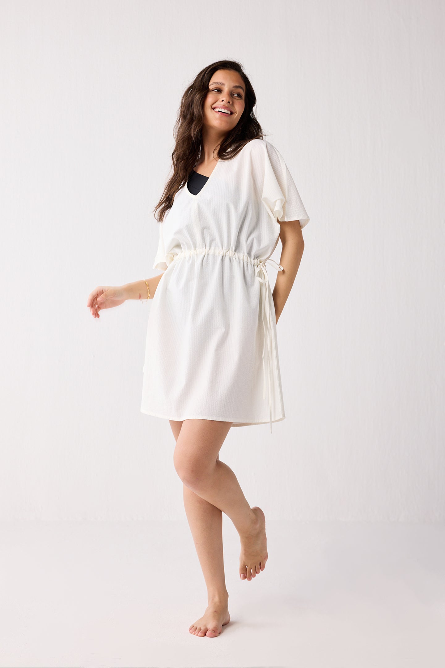 Woman wearing a white dress on a plain background