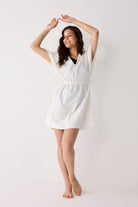 Woman wearing a white dress against a plain background