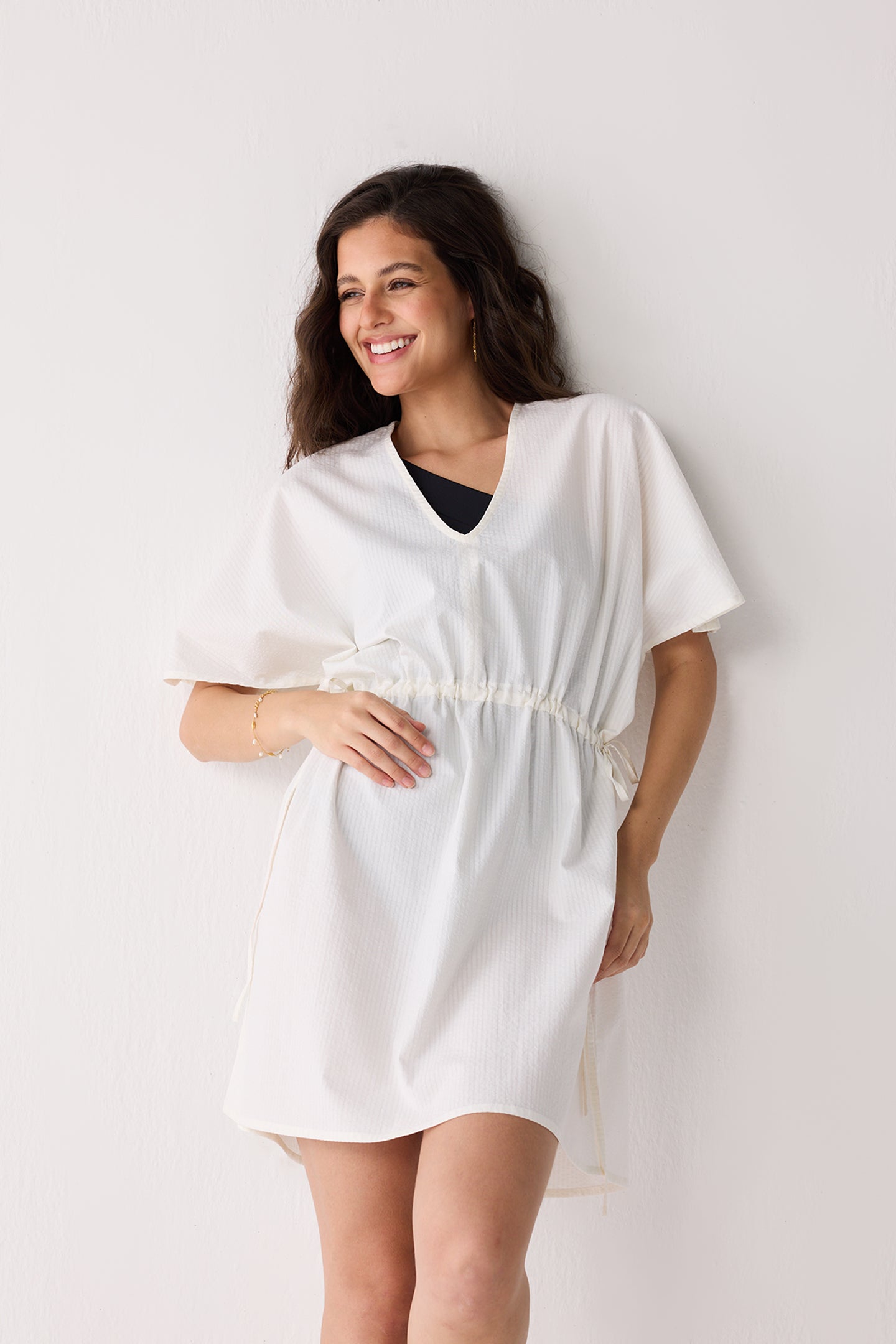 Woman wearing a white dress against a plain background
