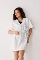 Woman wearing a white dress against a plain background