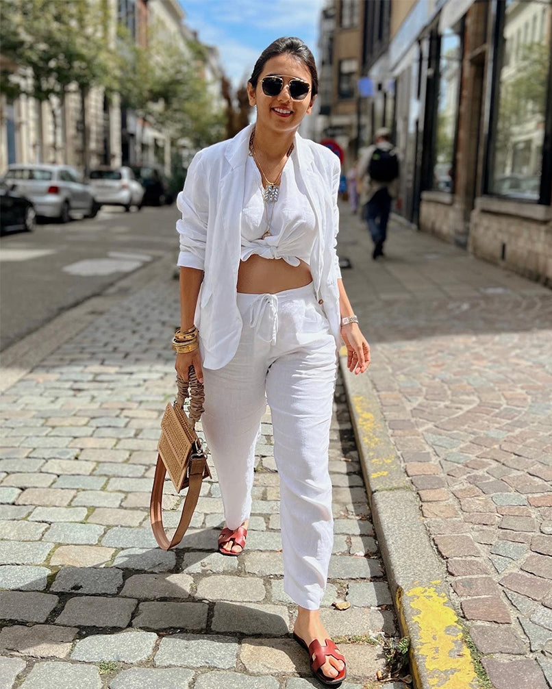 Woman in a white outfit walking on a street