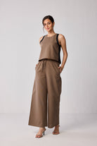Woman wearing the Matching Set with Wide-leg Pants and Solid Brown Top in Brown by Reistor on a light gray background.