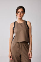 Woman wearing a Reistor Matching Set with Wide-leg Pants and Colorblock Top in Brown, featuring a brown sleeveless top and matching pants against a plain background.