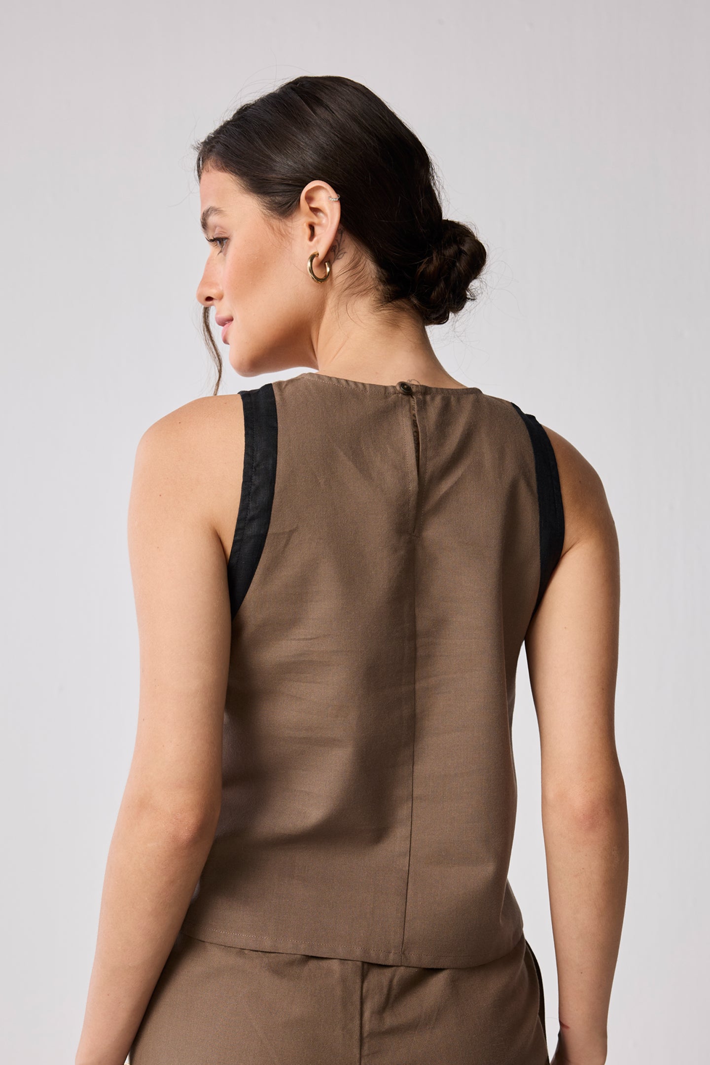 Close-up of the back of a brown colorblock top, part of a matching wide-leg pant set, highlighting the fabric texture and black trim.