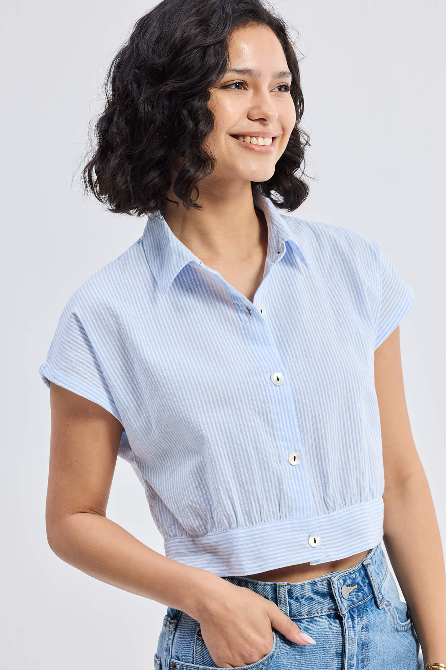 Rear view of a model in the Reistor Oversized Crop Shirt in Classic Stripes, showing the unique gathered elasticated back detail and casual cropped fit.