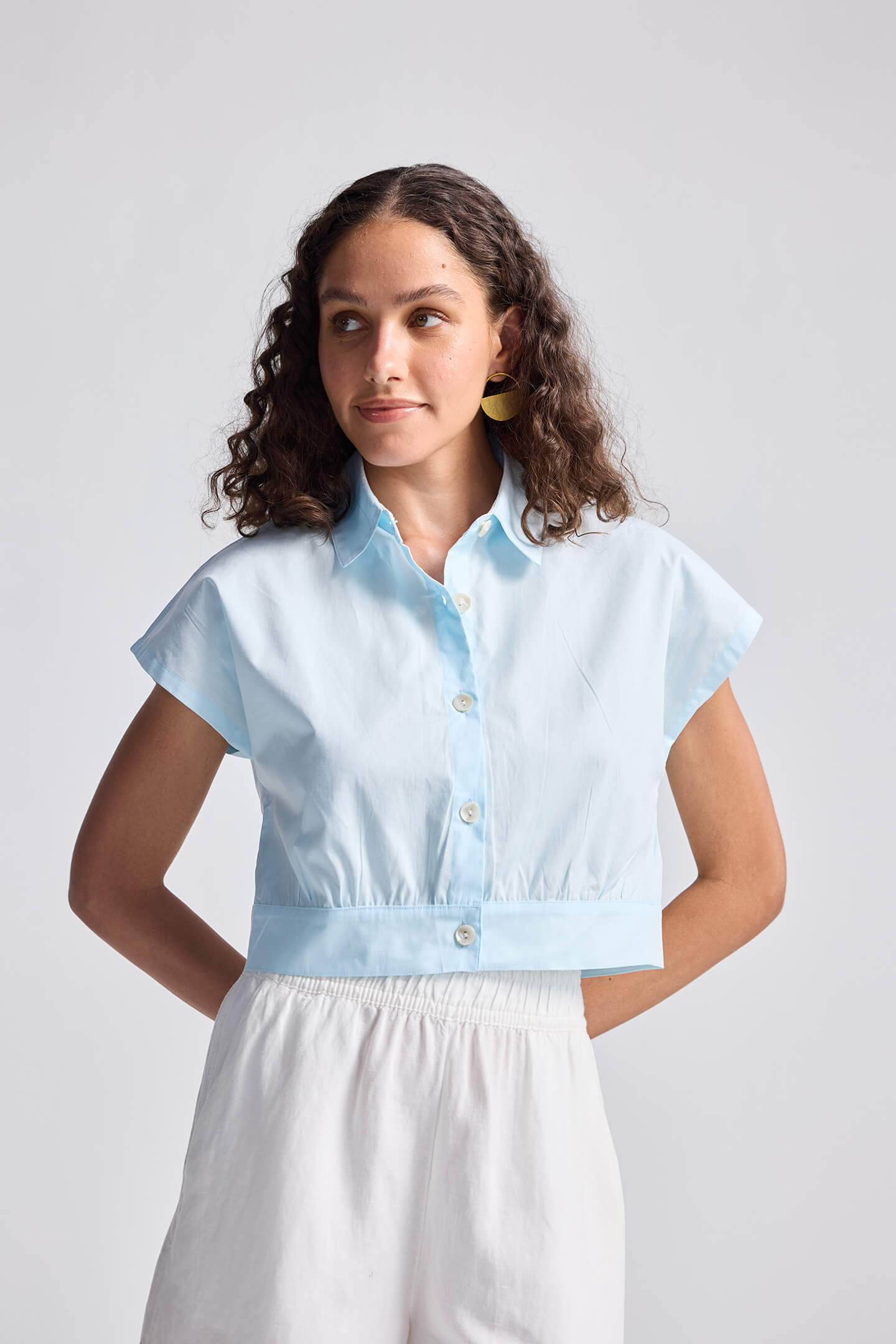 A model wearing the light blue reistor Oversized Crop Shirt in Summer Blue, featuring a button-down front and cropped fit.
