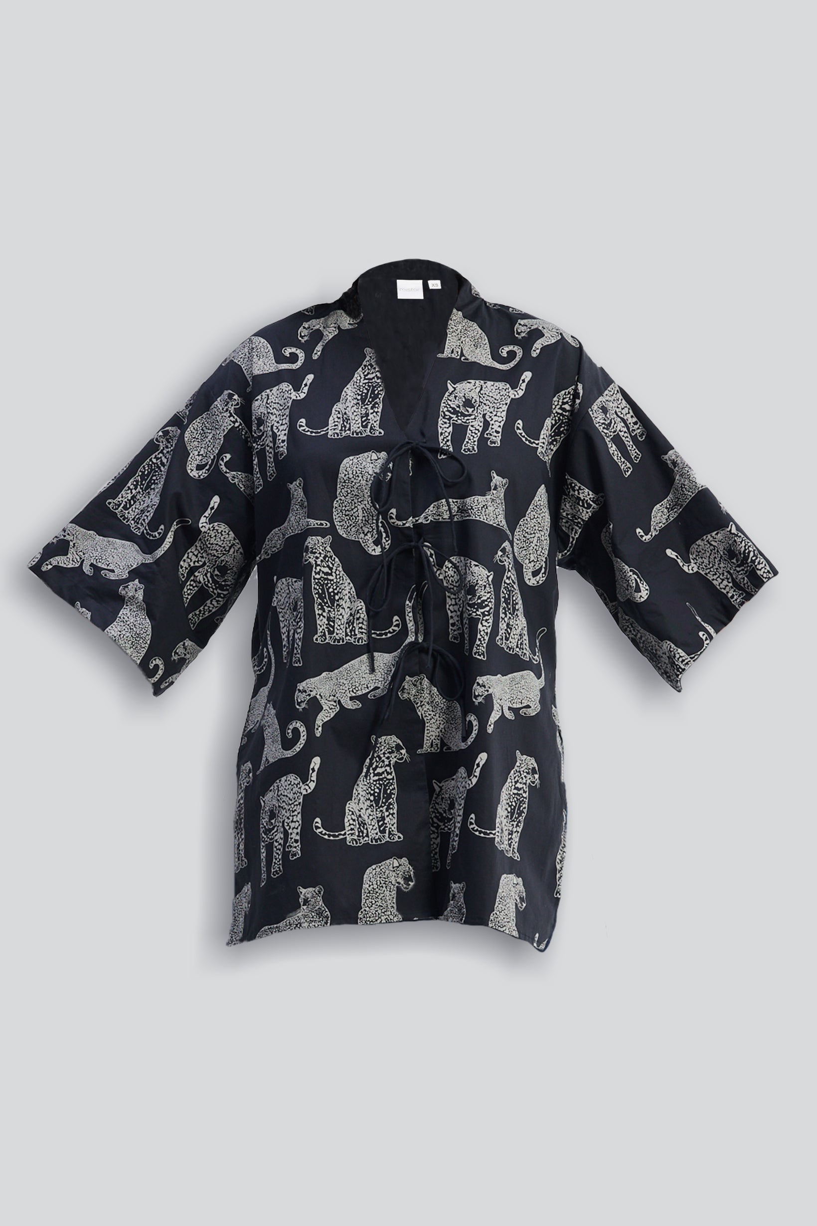 Black kimono-style garment with a white animal print pattern by reistor, styled on a light gray background.