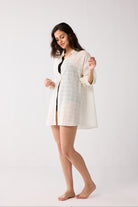 Woman wearing a white checkered jacket on a white background