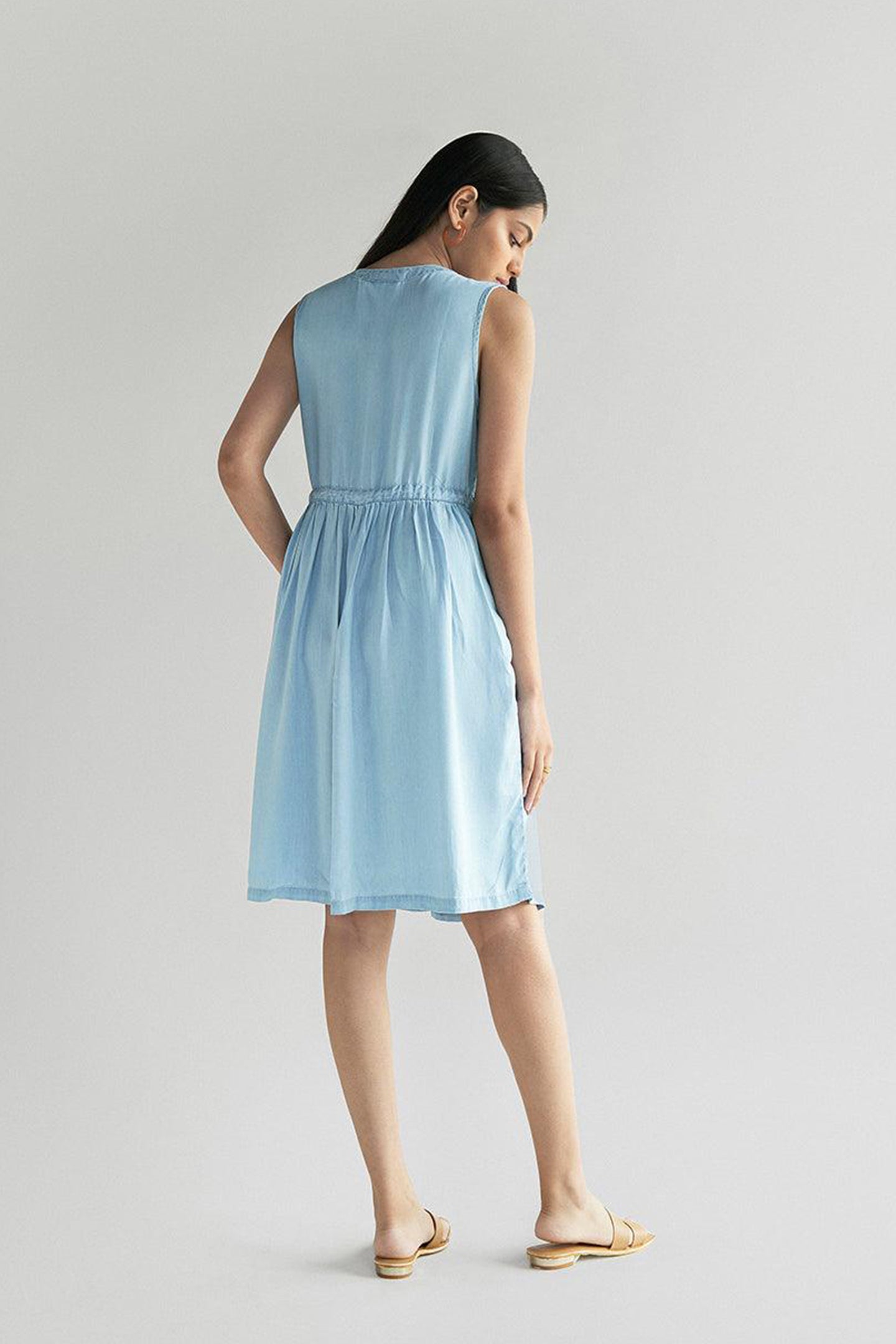 Back view of Reistor Pina Colada Dress in Ocean Blue, sleeveless V-neck midi dress with a gathered drawstring waist, breathable sustainable women's summer outfit.