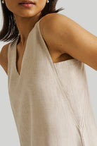 Reistor Reading Tea Leaves Dress in Ecru featuring a sleeveless V-neck design, breathable sustainable fabric, relaxed fit, and elegant minimalist style.