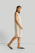 Reistor Reading Tea Leaves Dress in Ecru, sustainable sleeveless V-neck midi dress with side slits, breathable fabric, relaxed fit, and timeless style.